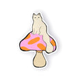 A die-cut sticker featuring a cream-colored cat sitting on a pink and orange spotted mushroom cap, shown on a plain white background with a soft drop shadow.