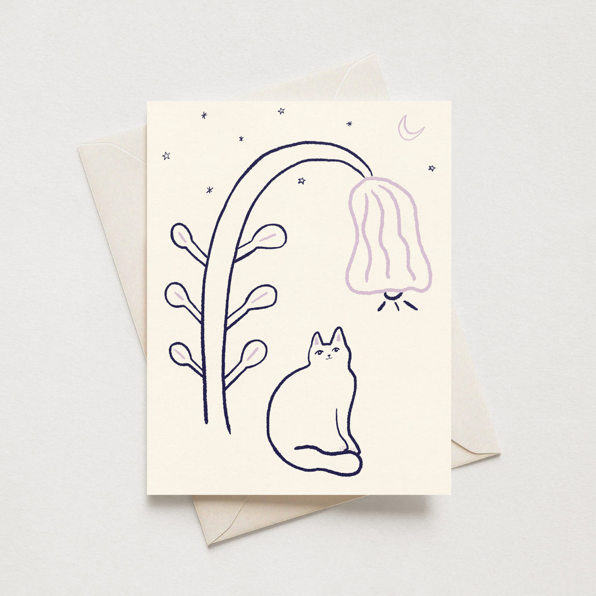 A cream-colored greeting card with a minimalist line drawing of a cat under a glowing lantern plant, shown with a matching envelope on a light gray background.