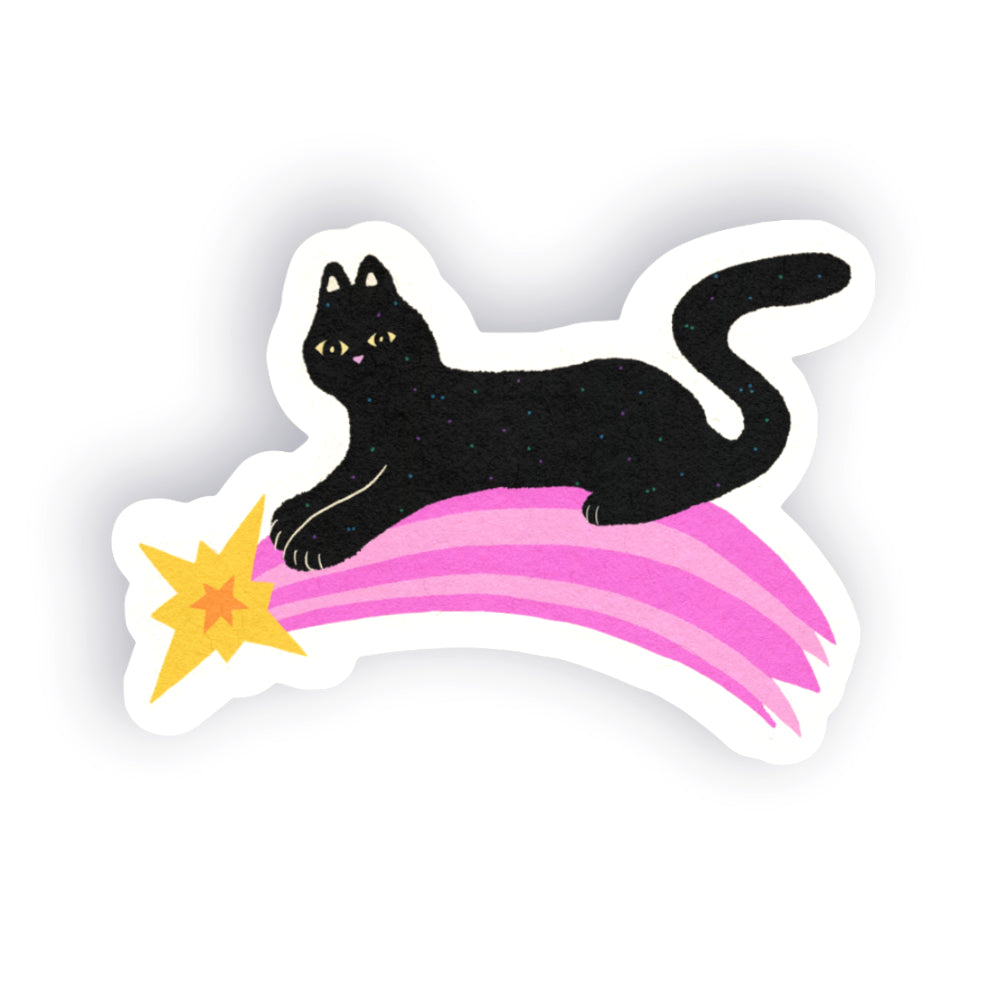 A die-cut sticker featuring a black cat lying on a pink striped shooting star with a yellow burst at the front, shown on a plain white background.